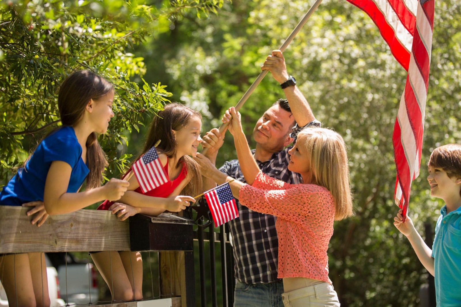 A Veteran family raising an American flag together in their yard