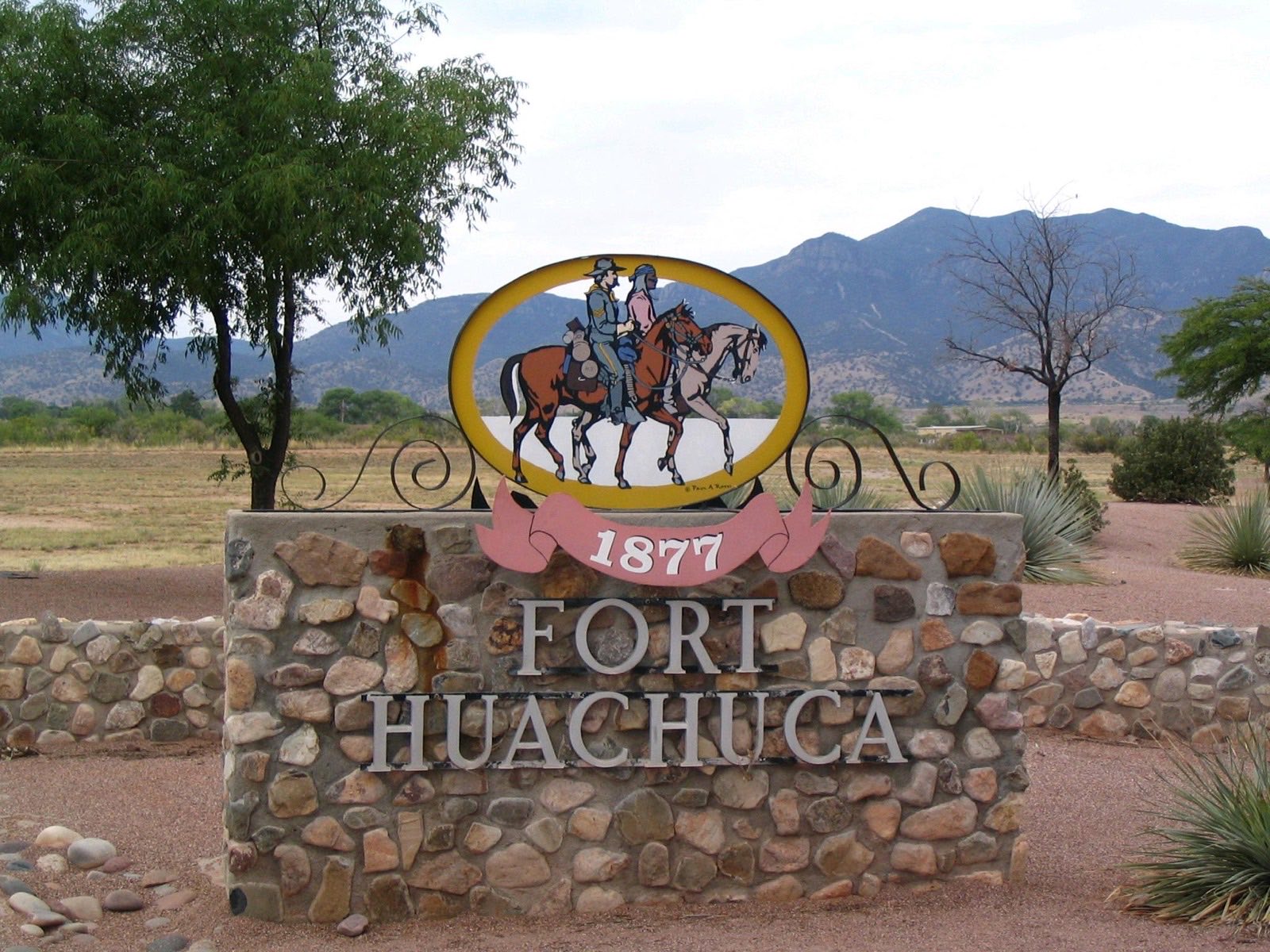 The historic Fort Huachuca 1877 entrance sign with the Huachuca Mountains behind it in Sierra Vista, Arizona